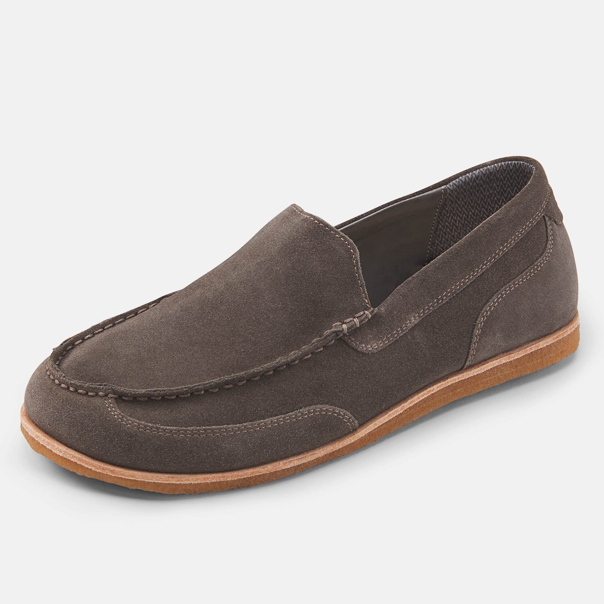 Grauer Wildleder-Slipper mit hellbrauner Sohle. Nahtdetails und flache Form. Breite Passform.