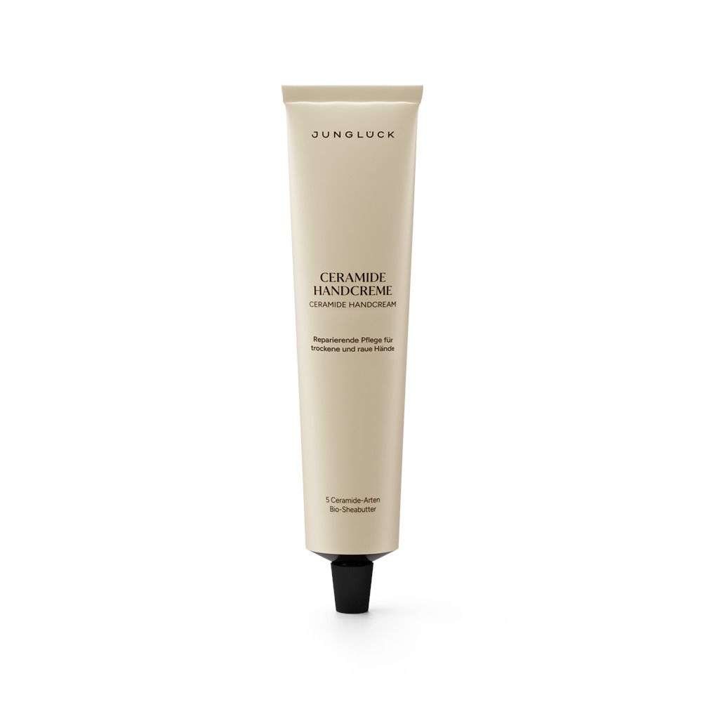 Beige Tube mit schwarzem Verschluss. Aufschrift: JUNGLÜCK, Ceramide Handcreme. Text darunter.