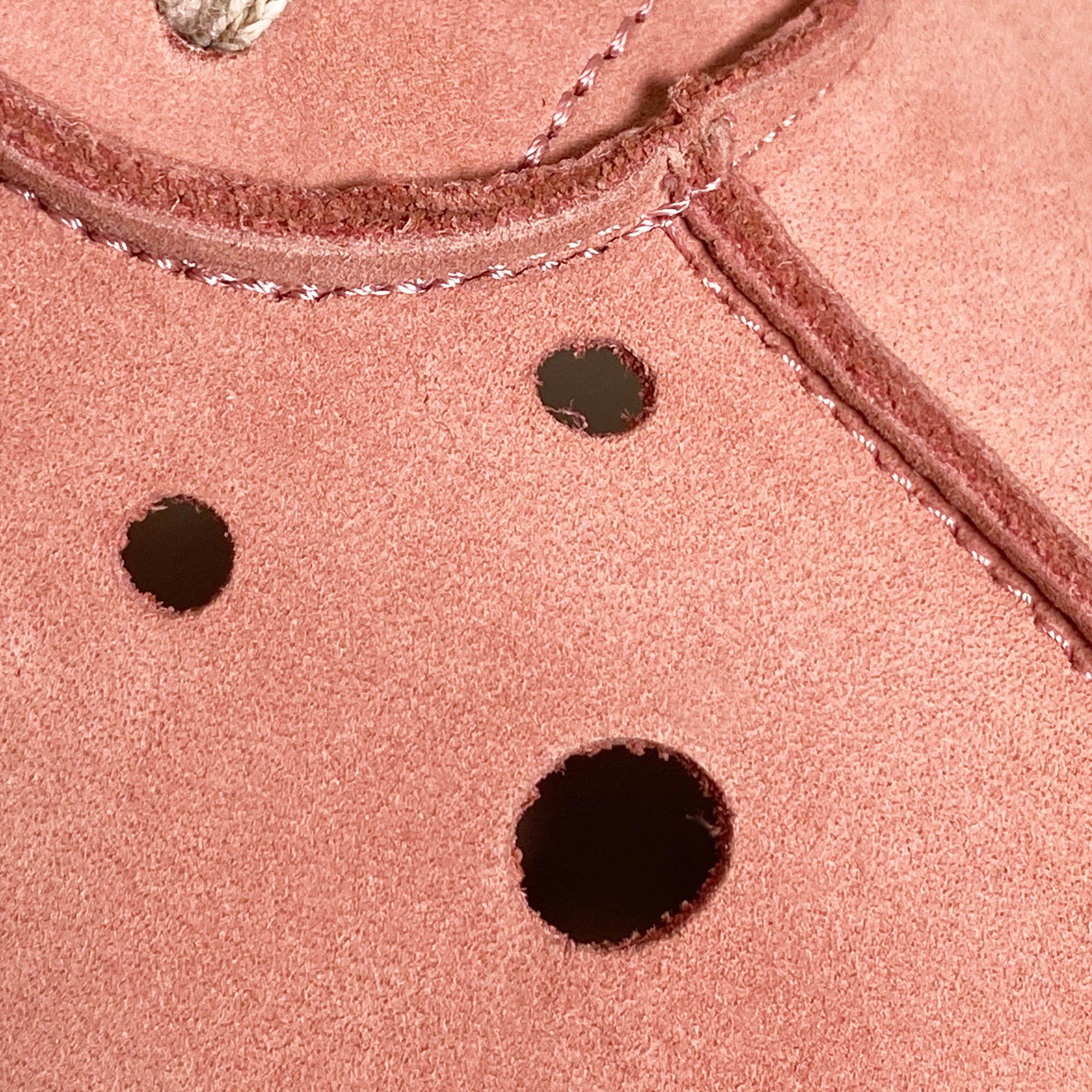 Nahaufnahme der rosa Stiefelette mit Perforationen. Sichtbar sind Löcher und Nähte.
