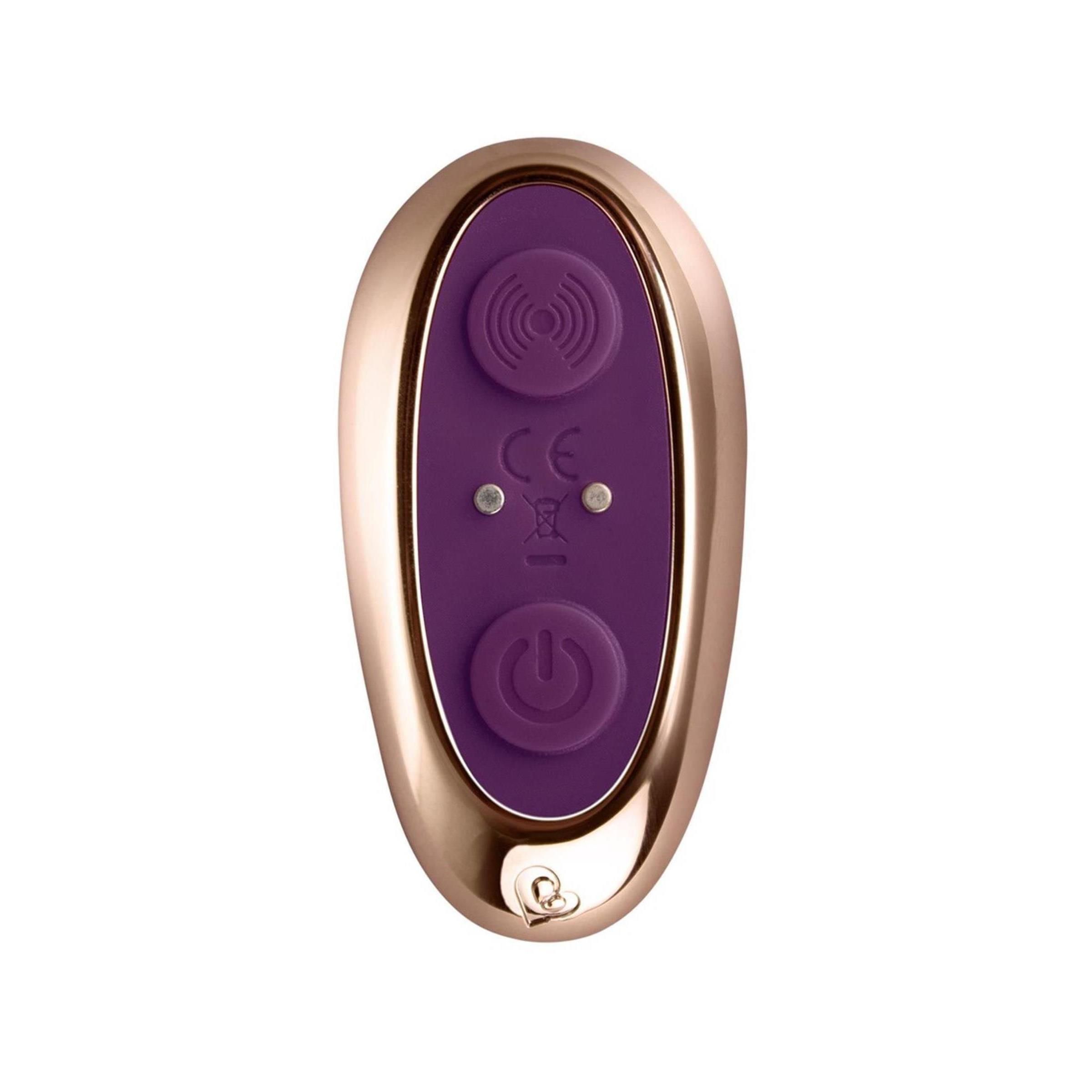 Nahaufnahme der Fernbedienung. Goldfarbener Rahmen, lila Oberfläche mit zwei Knöpfen und CE-Kennzeichnung.