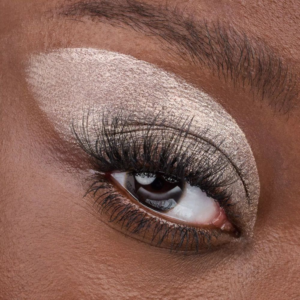 Nahaufnahme eines Auges mit Glanz-Tönung. Aufgetragen auf dem Augenlid. Lange Wimpern.