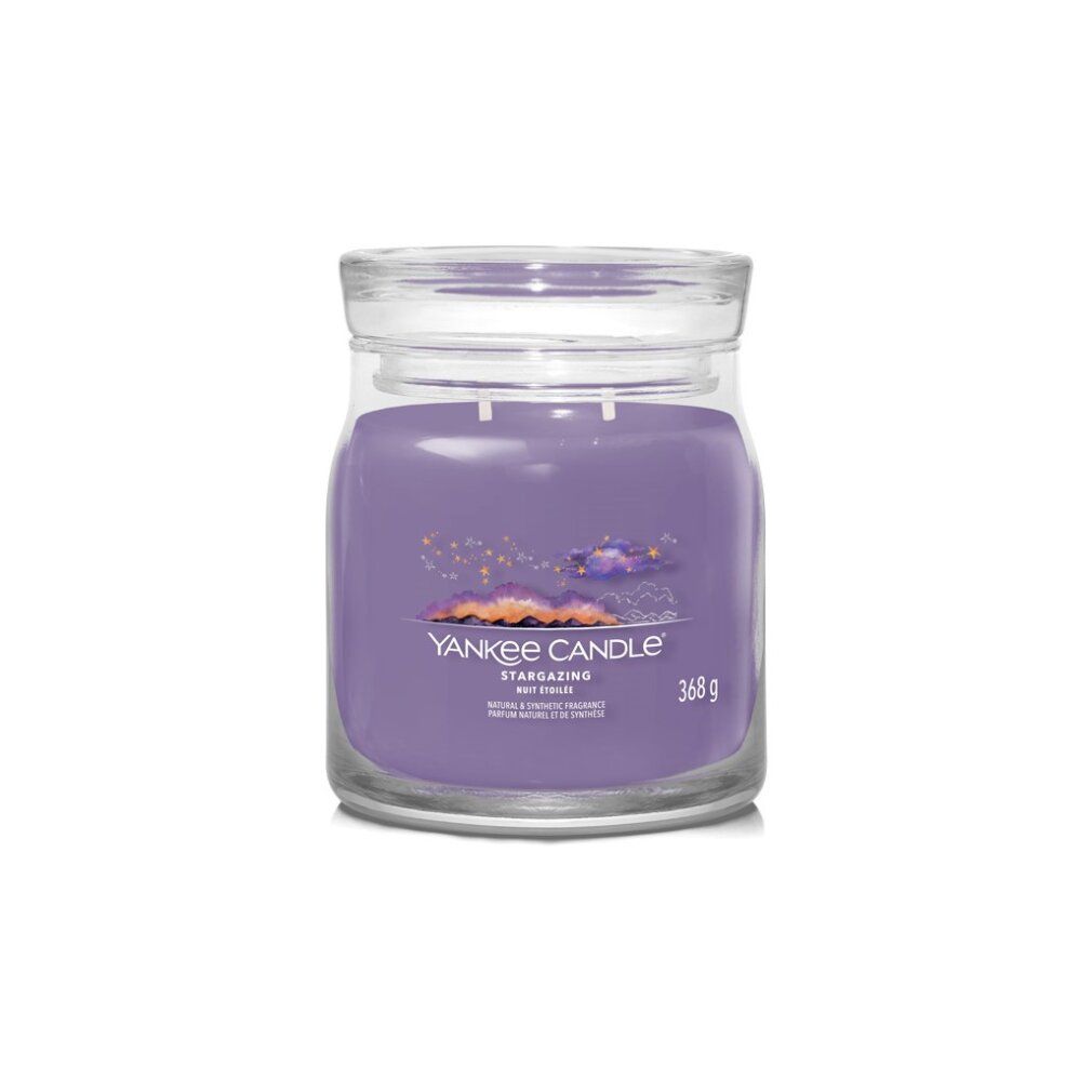 Violette Kerze im Glasbehälter mit Deckel. Aufschrift: Yankee Candle, Stargazing, 368 g. Natürliche und synthetische Duftstoffe.