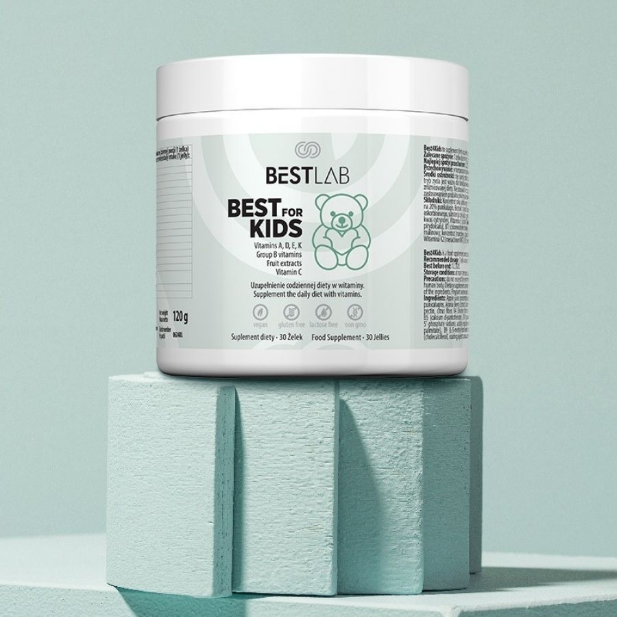 Weiße Dose BEST LAB BEST FOR KIDS auf einem hellblauen Podest. Enthält Vitamine A, D, E, K, B-Gruppe und Vitamin C. 120g, 30 Gelees.