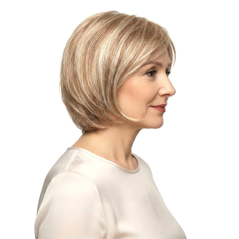 Perücke STOCKHOLM, blond, mittellang, mit Pony. Frau mit Perücke, Seitenansicht, vor weißem Hintergrund.