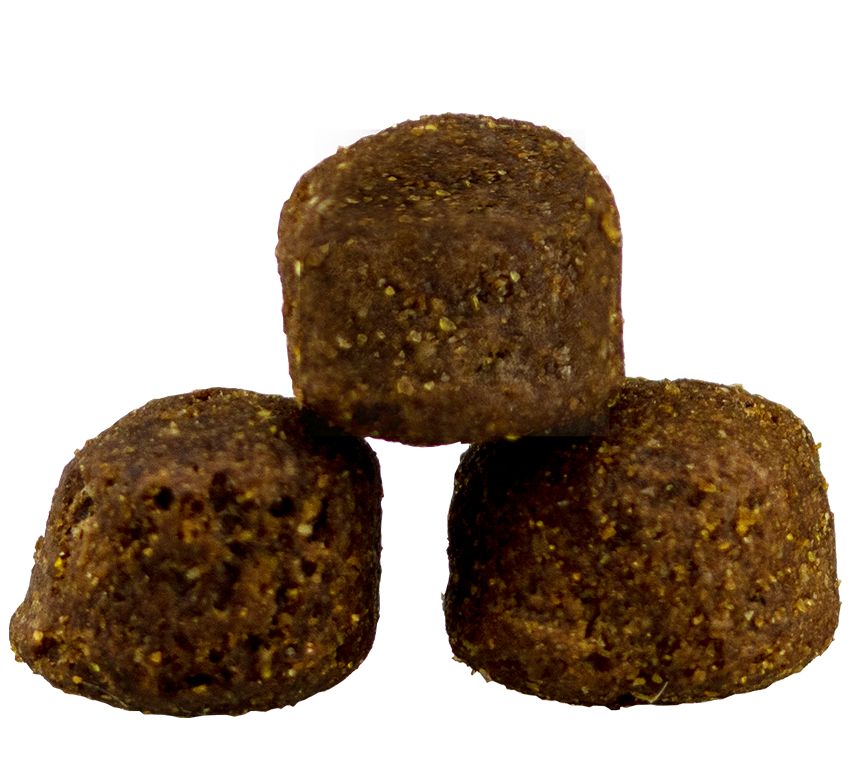 Drei braune, runde Kroketten. Hundefutter. Nahaufnahme auf weißem Hintergrund.