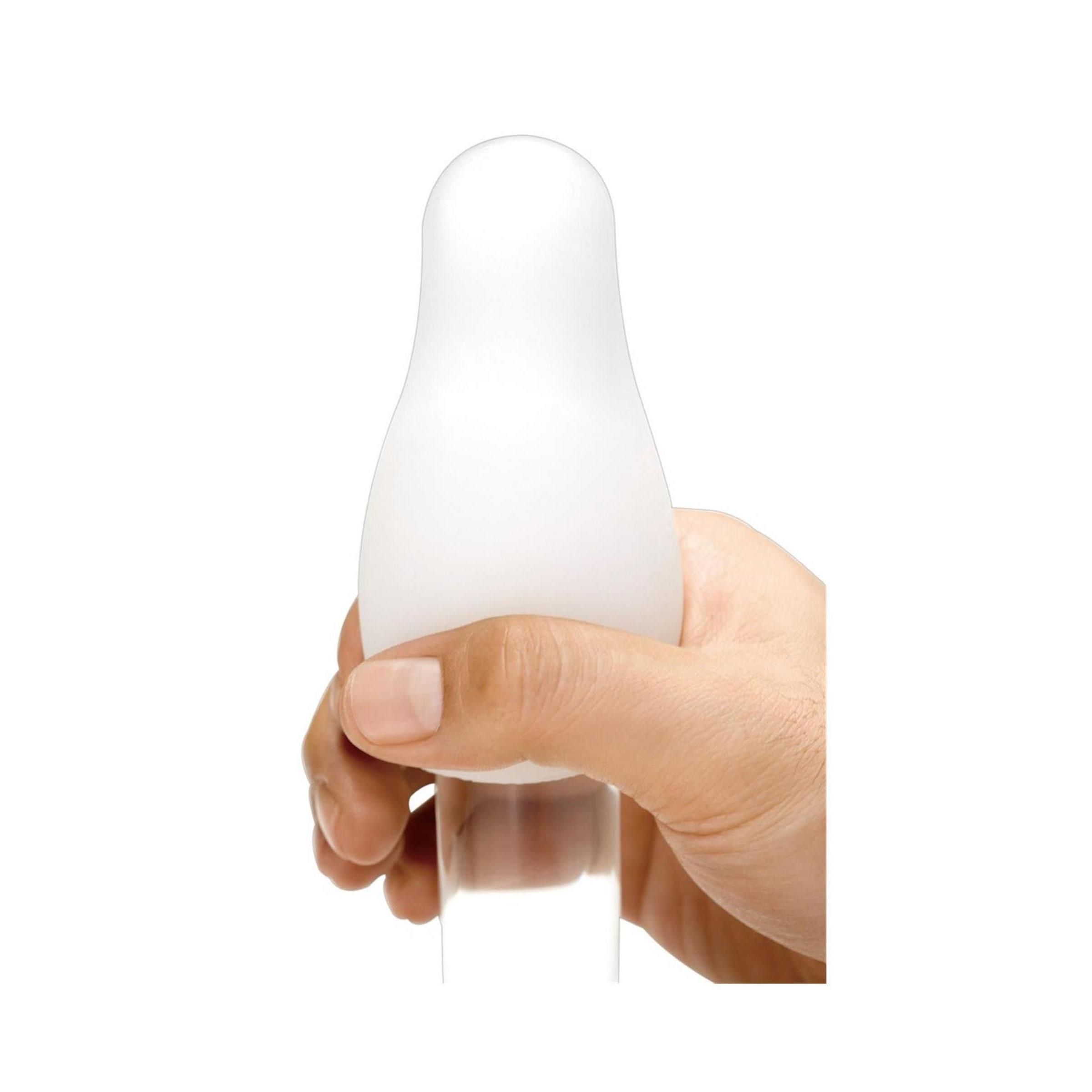 Weißes, tropfenförmiges Objekt in einer Hand gehalten.