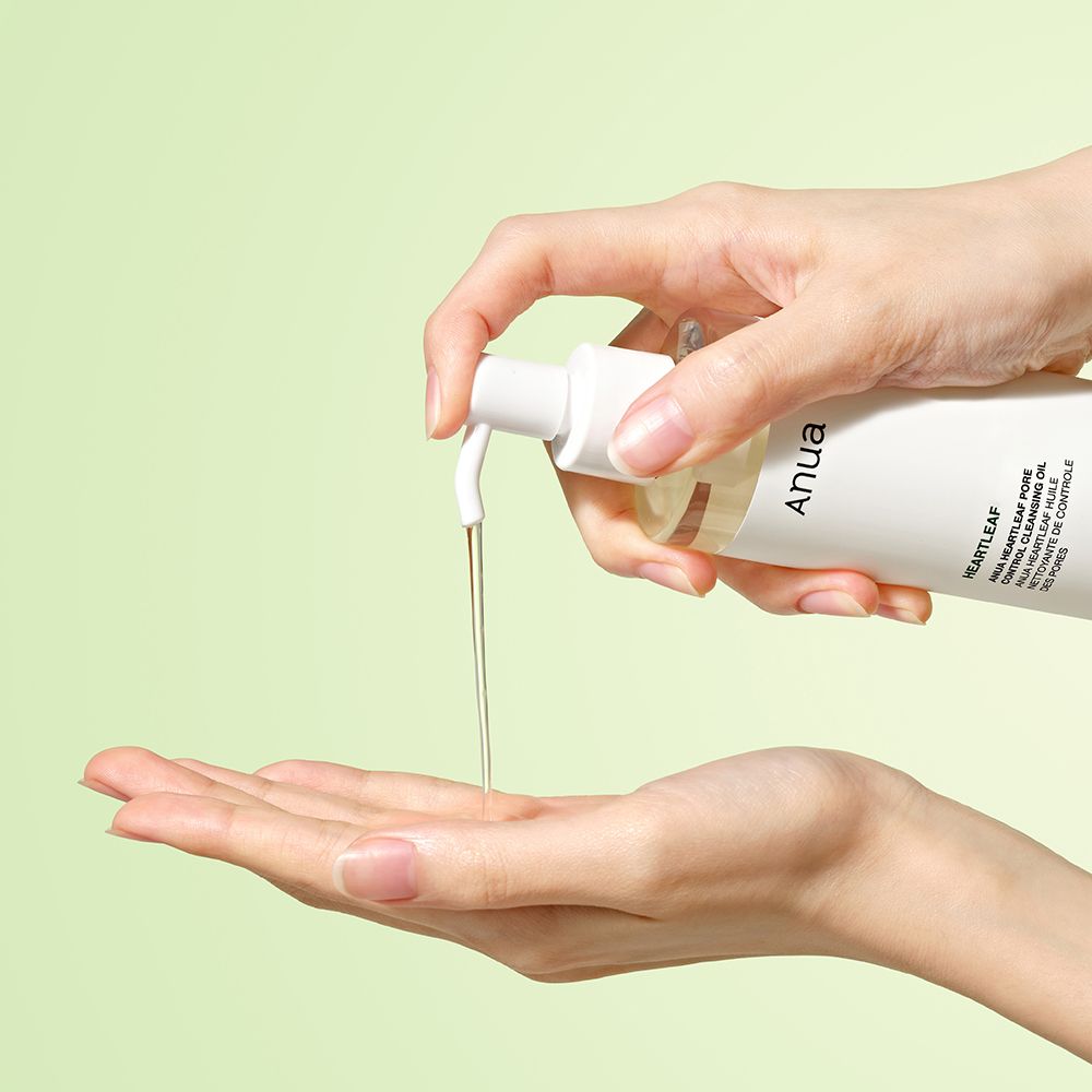 Hand gibt Anua Heartleaf Pore Deep Cleansing Oil in die Handfläche.