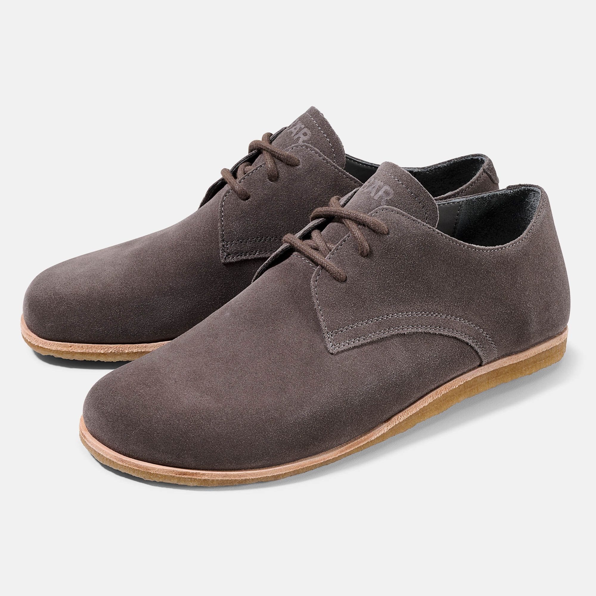 Zwei braune Schnürschuhe aus Wildleder. Hellbraune Sohle, Schnürsenkel. BÄR-Logo auf der Zunge.