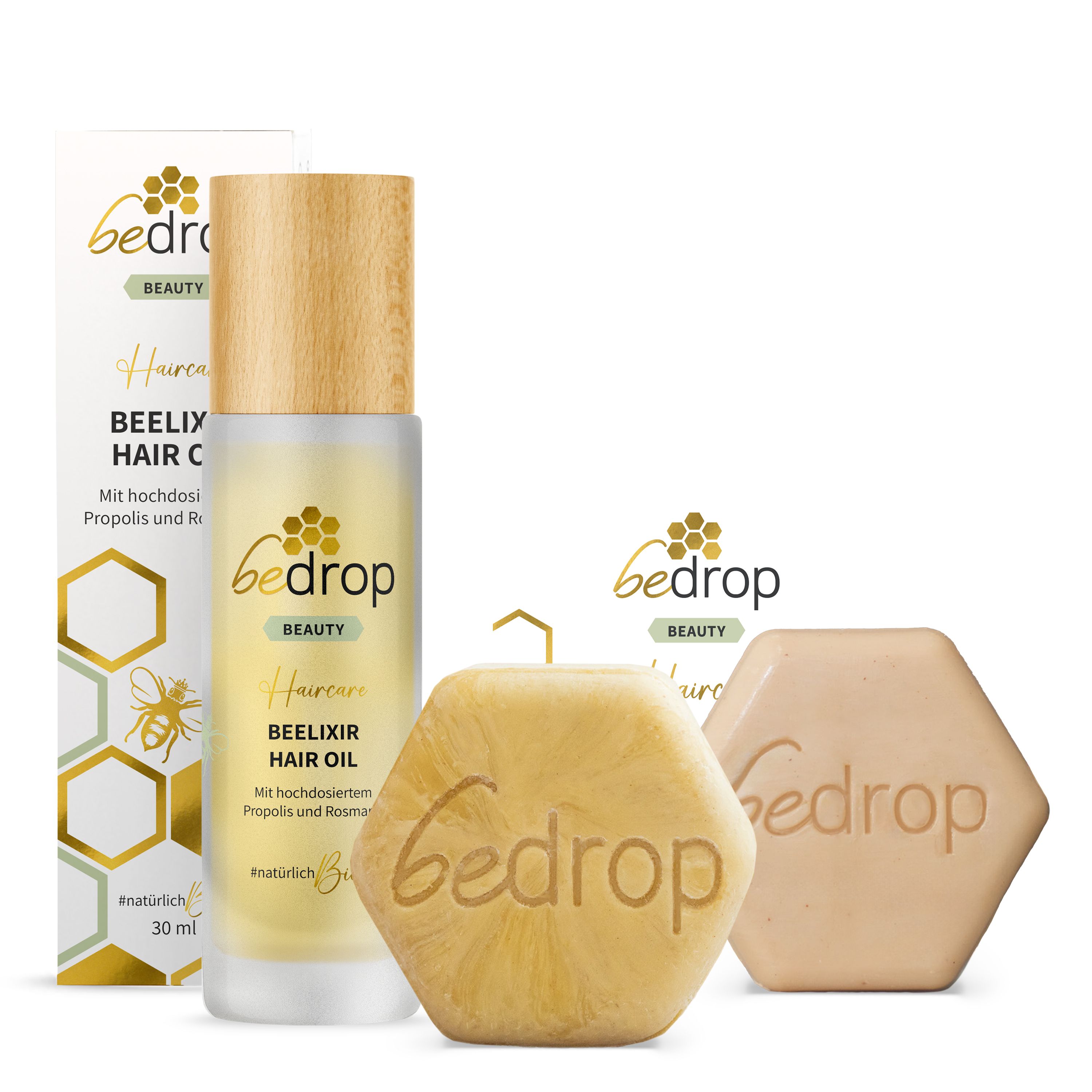 Produkt-Set. Haaröl-Flasche, Seifenstück und Schachtel. Aufschrift: Beelixir Hair Oil und Gelée Royale Shampoo.