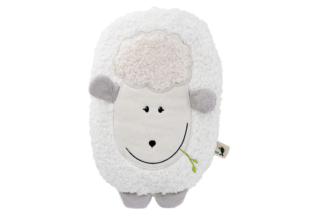 Weißes, flauschiges Wärmflaschen-Lamm mit grauem Kopf, Armen und Füßen. Es hat ein lächelndes Gesicht und einen grünen Halm im Mund.