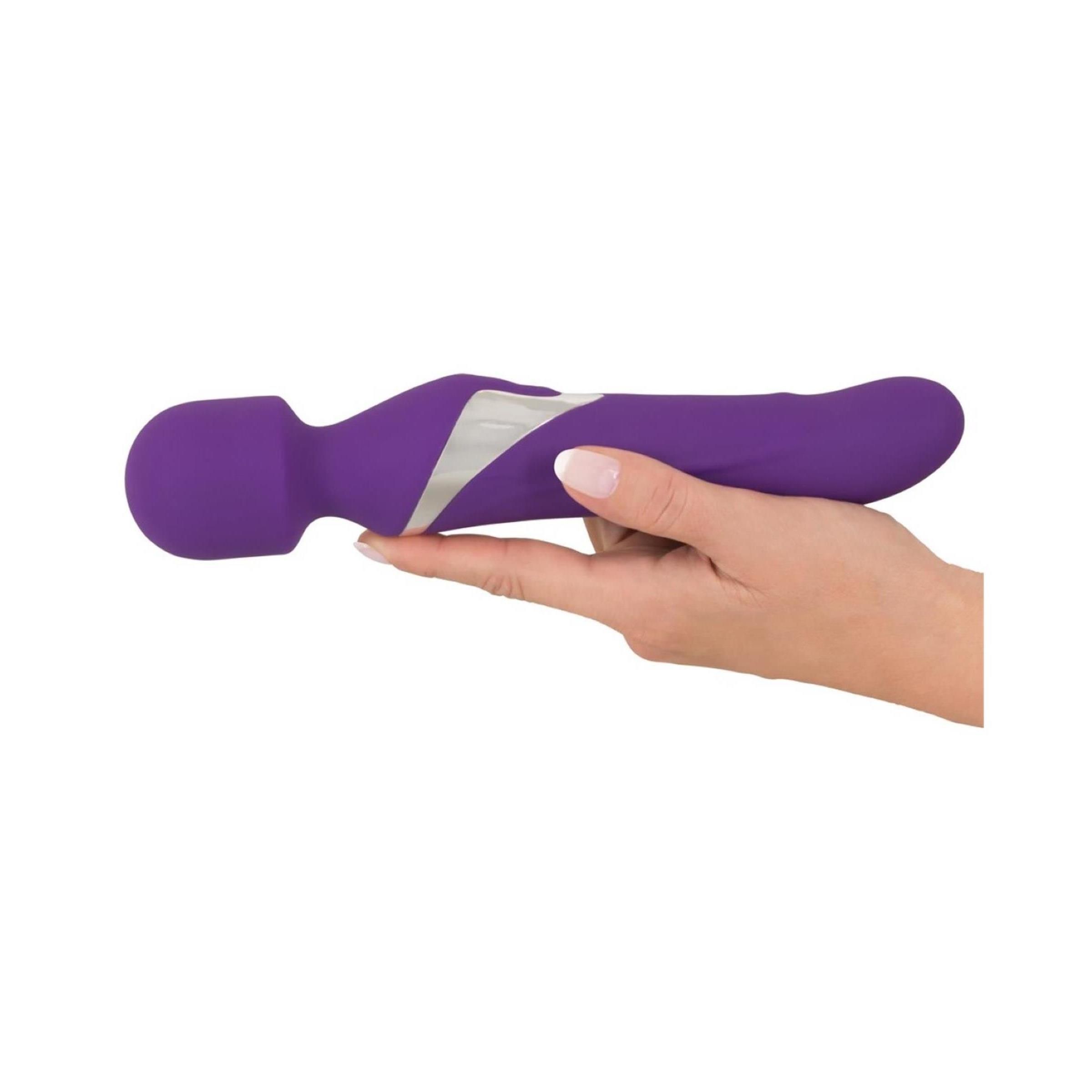 Lila Massagestab in einer Hand gehalten. Silberfarbener Akzent. Abgerundeter Kopf und ergonomische Form.