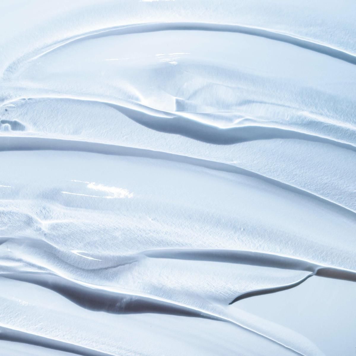 Nahaufnahme einer hellblauen, cremigen Substanz. Die Textur ist glatt und wellig.