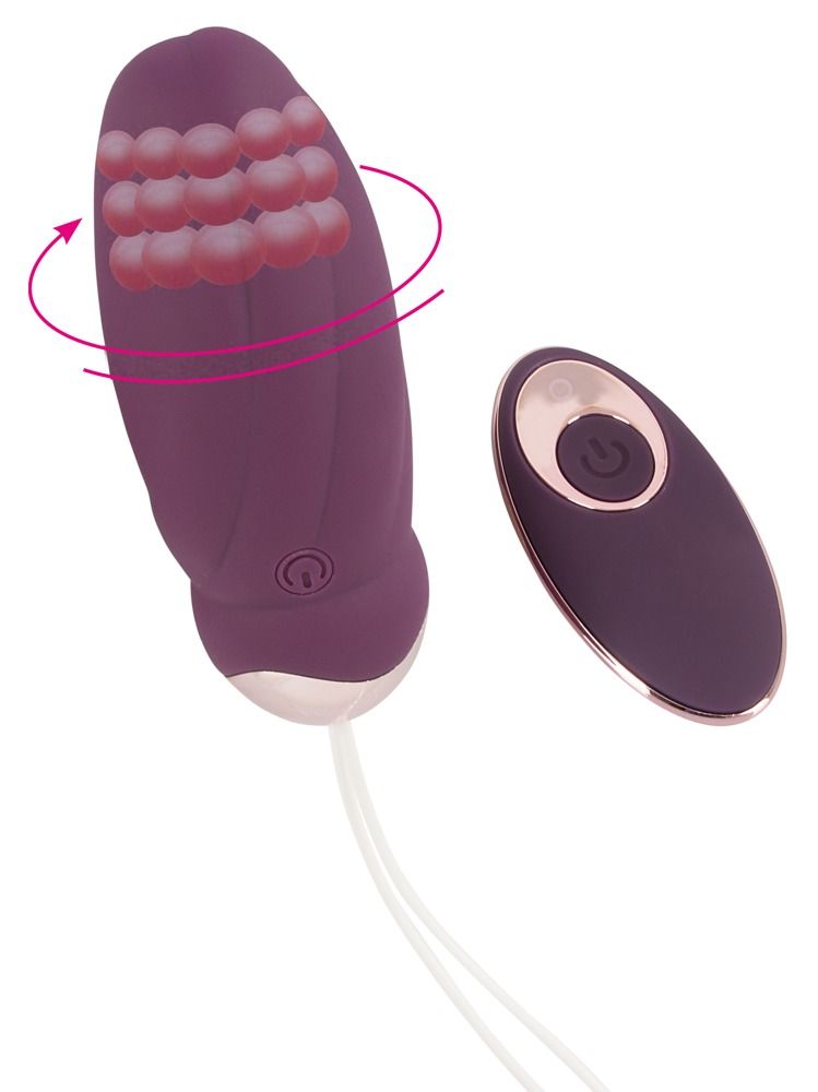 Lila Vibrator mit rotierenden Kugeln. Fernbedienung. Goldfarbene Akzente. Auf der Fernbedienung ist ein Knopf.