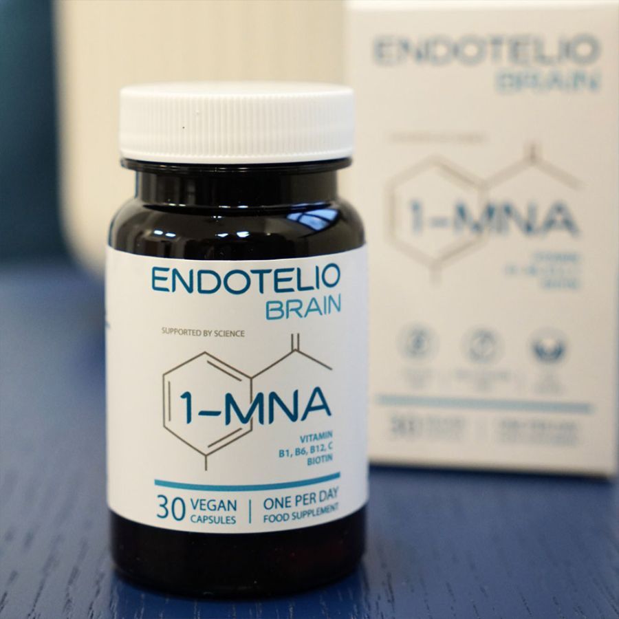 Braune Glasflasche mit weißem Deckel und Produktaufdruck. Aufschrift: ENDOTELIO BRAIN, 1-MNA, 30 vegane Kapseln. Daneben eine Produktverpackung.
