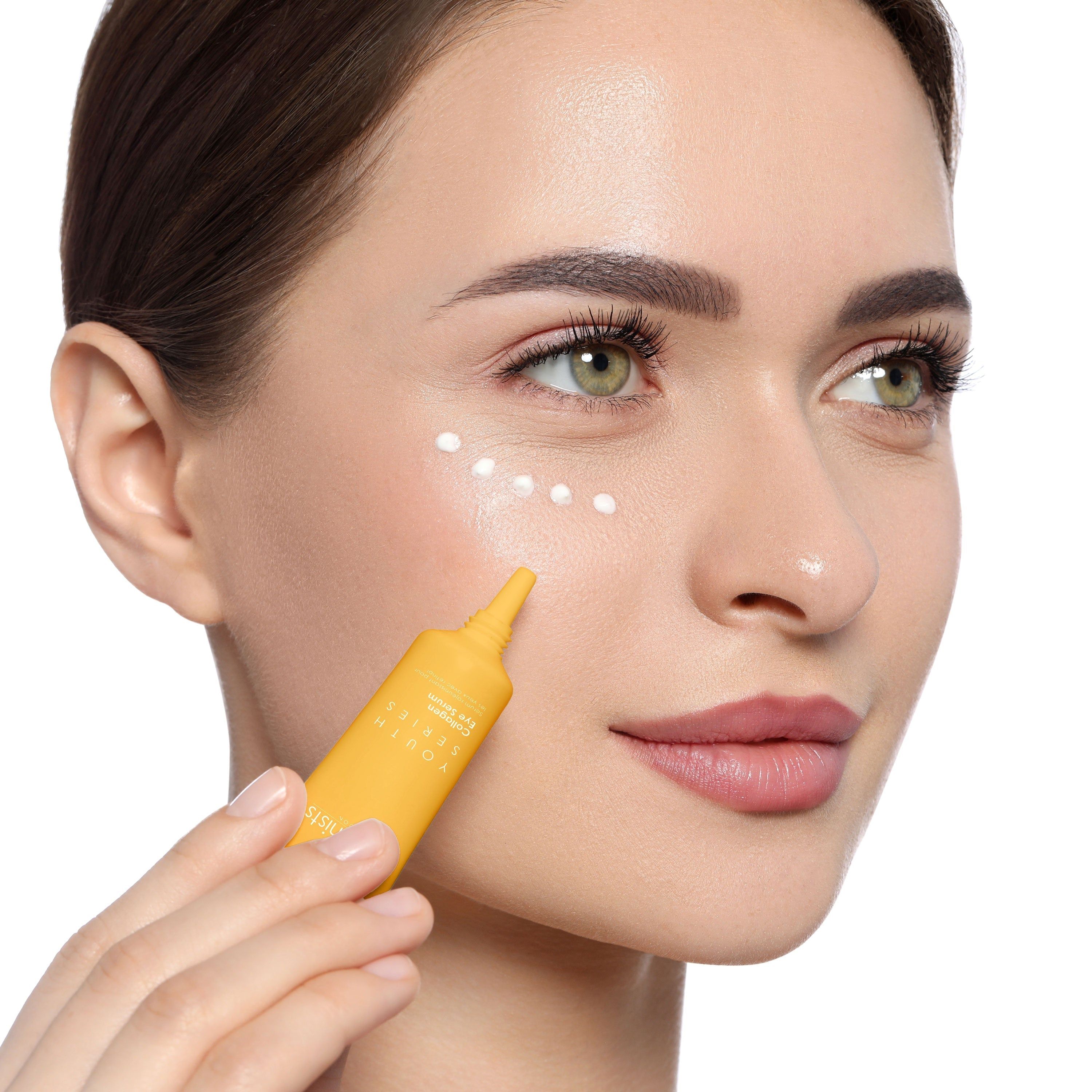 Frau trägt SkinChemists Youth Series Collagen Eye Serum auf. Gelbe Tube wird verwendet. Produktname sichtbar.