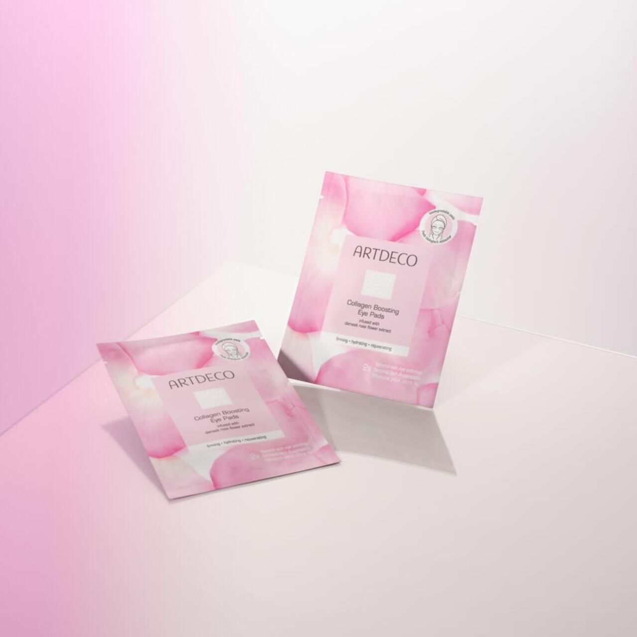 Zwei Artdeco Collagen Boosting Eye Pads Packungen. Rosa Verpackung mit Produktinformationen. Aufschrift: Artdeco, Collagen Boosting Eye Pads.