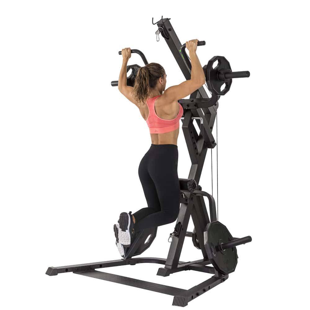 Fitnessgerät mit Klimmzugstange und Gewichten. Eine Person zieht sich hoch. Schwarze Konstruktion mit grünen Akzenten. Gewichte an den Seiten.