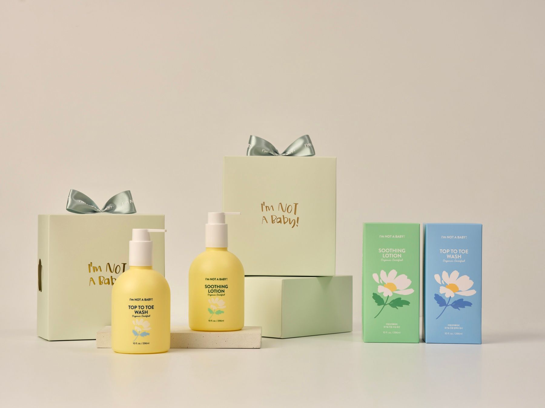 Geschenkboxen, Flaschen und Schachteln mit floralen Motiven. Aufschrift: I'm NOT A BABY. Produkte auf einer weißen Oberfläche.