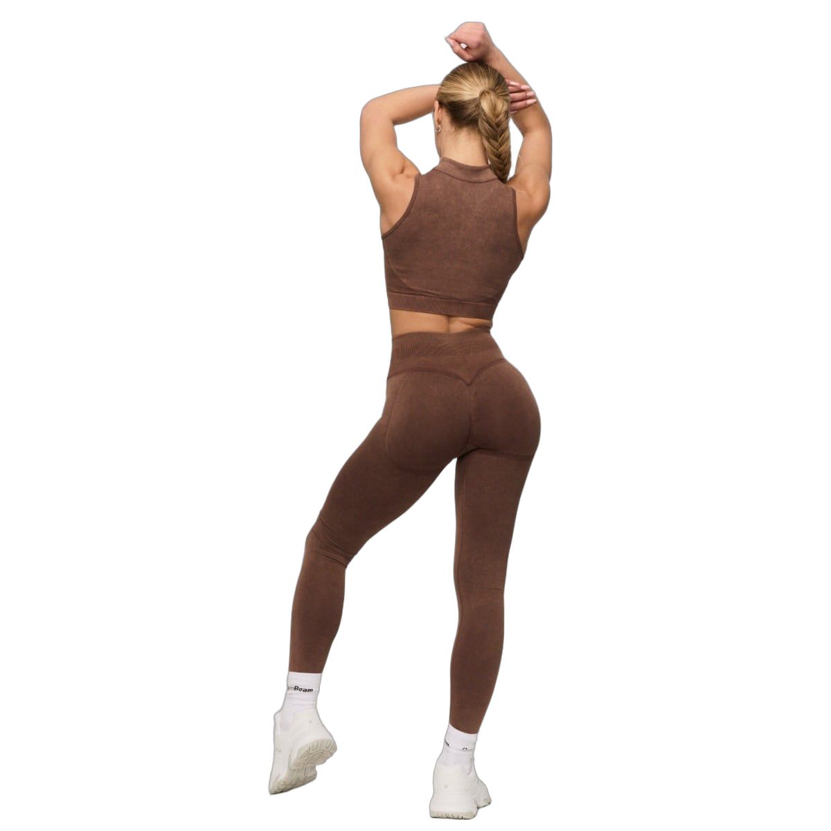 Rückansicht einer Frau in braunen, nahtlosen High-Waist-Leggings und passendem Sport-BH.