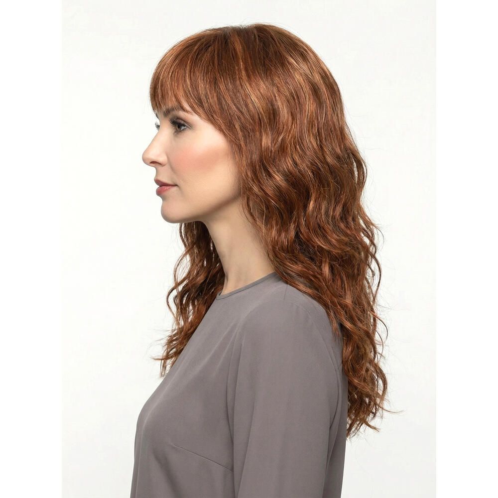 Perücke Kiky von trendhair. Rötlich-braune, gewellte Kunsthaarperücke mit Pony. Profilansicht einer Frau.