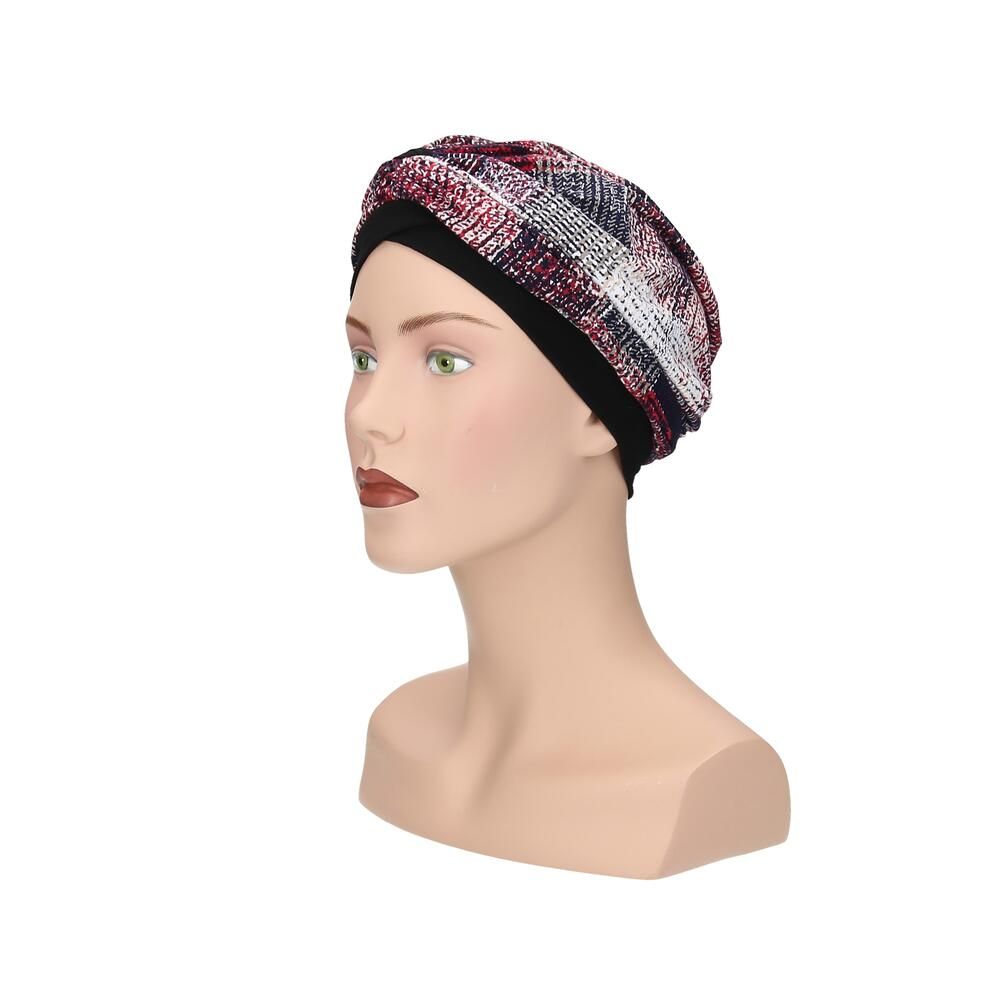 Turban mit mehrfarbigem Muster auf einem Schaufensterpuppenkopf. Schwarzes Stirnband. Seitenansicht.