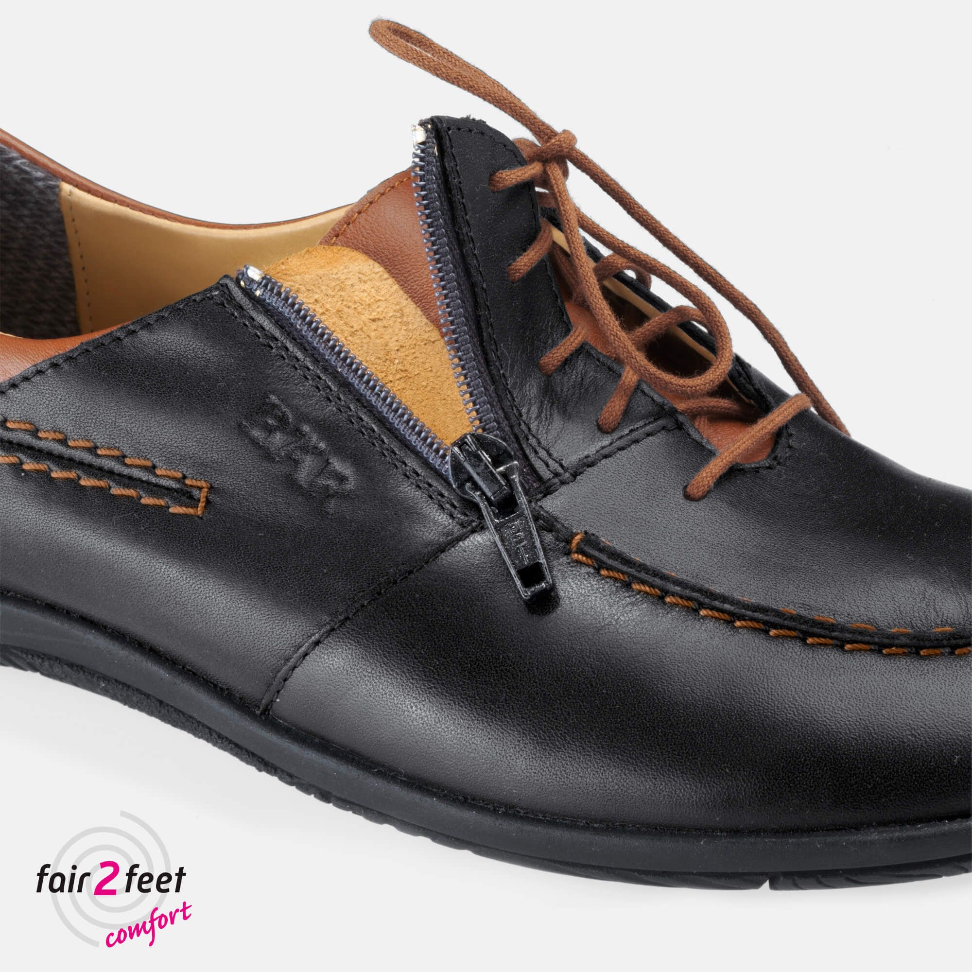 Nahaufnahme eines schwarzen Lederschuhs mit Reißverschluss. BÄR-Logo auf dem Schuh. Braune Akzente.