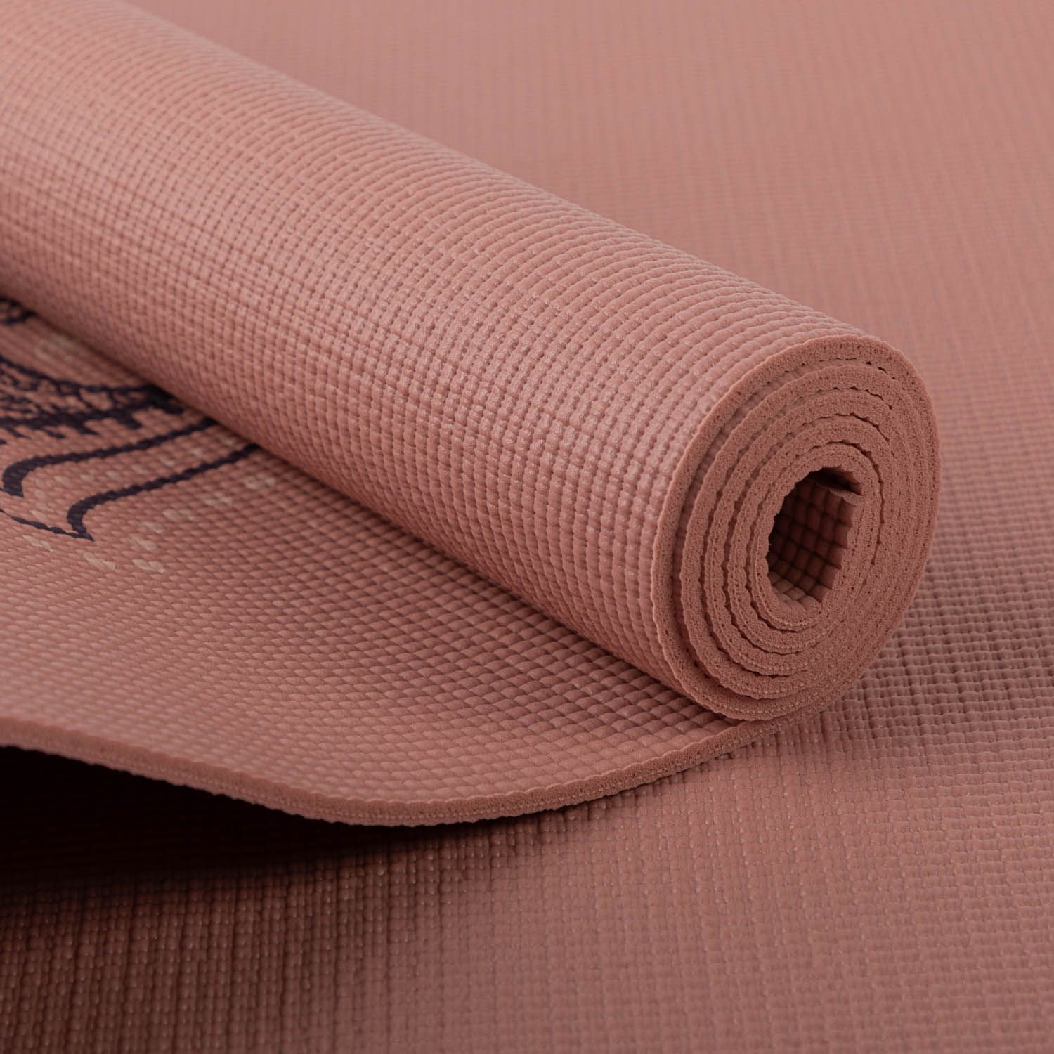 Gerollte, rosafarbene Yogamatte. Hamsa-Hand-Design teilweise sichtbar.