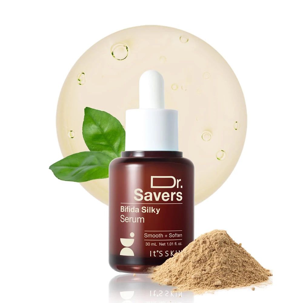 Braune Glasflasche mit Pipettenverschluss, gefüllt mit Bifida Silky Serum. Daneben ein Haufen Pulver und grüne Blätter.