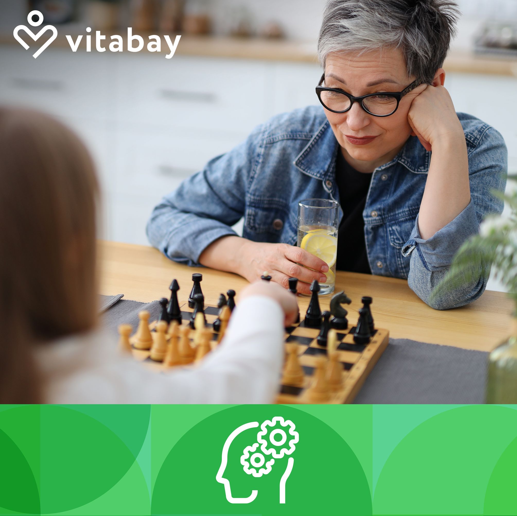 Zwei Personen spielen Schach. Eine Frau mit Brille und ein Schachbrett sind sichtbar. Im Hintergrund ein Tisch.