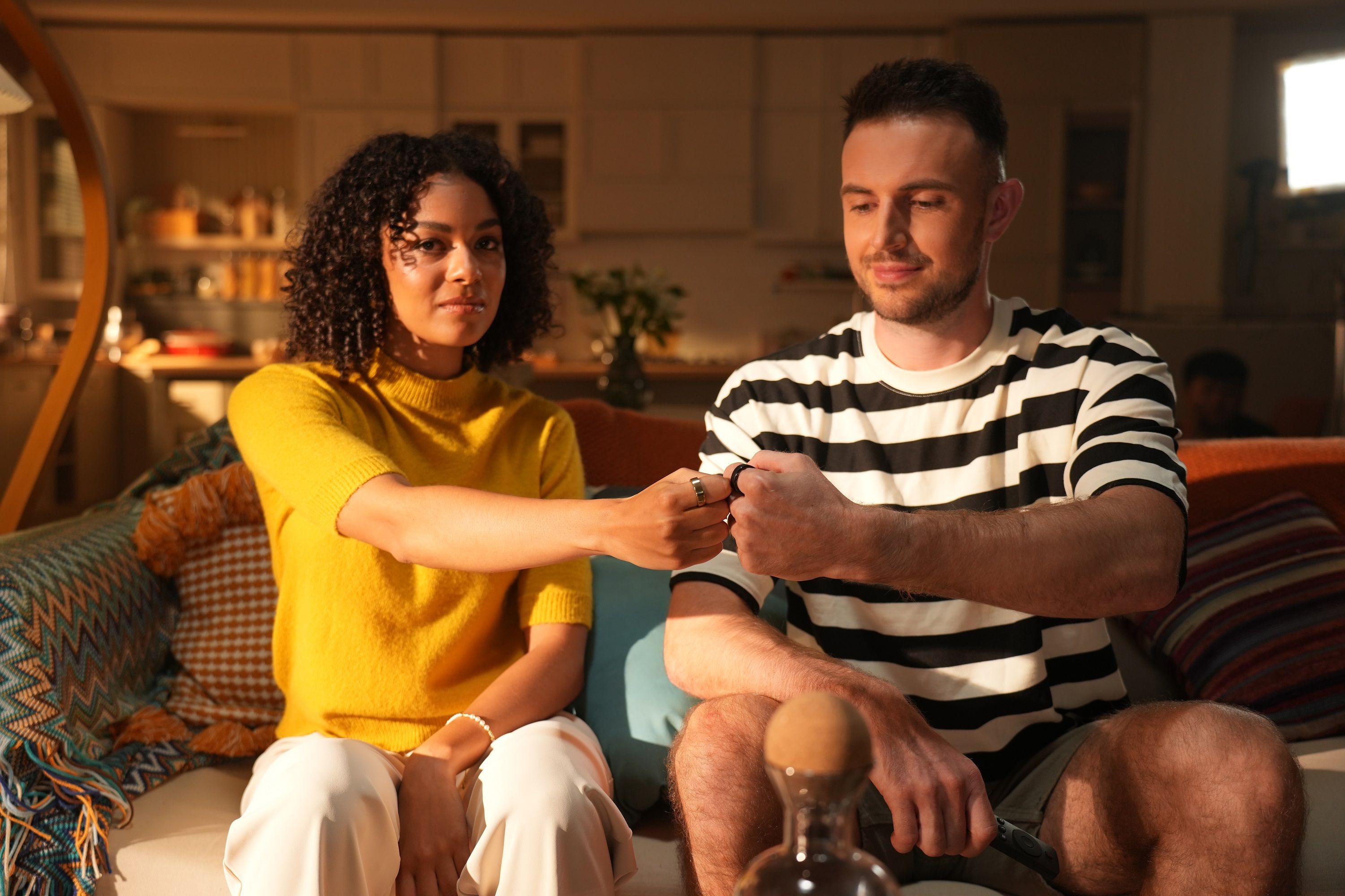Zwei Personen stoßen mit Fäusten an. Ringe sichtbar. Wellness-Produkt.