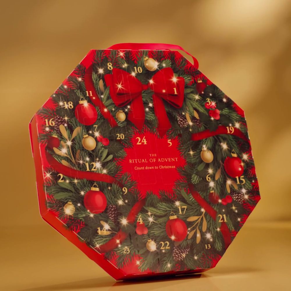 Achteckiger Adventskalender mit weihnachtlichem Design. Rote Schleife, Kugeln und Tannenzweige. Mit Aufschrift.