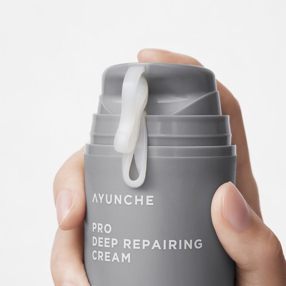 Hand drückt Pumpe von AYUNCHE PRO Deep Repairing Cream, weiße Creme kommt heraus.