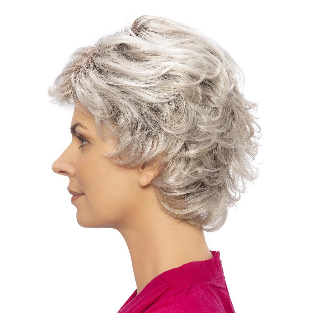 Seitenansicht einer Frau mit grauer, gewellter Perücke. Der Ansatz ist dunkelbraun. Die Perücke bedeckt den Kopf.