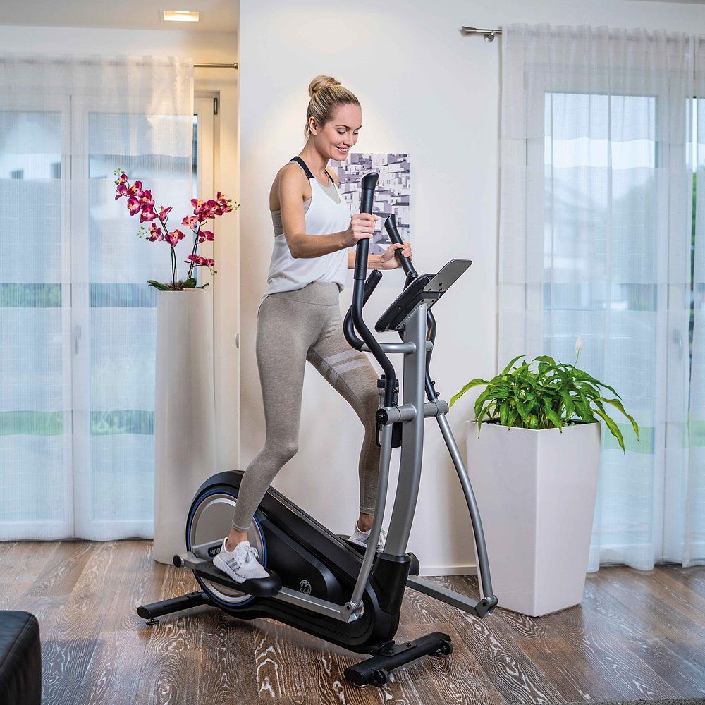 Frau trainiert auf dem Horizon Fitness Milos 3.0 Crosstrainer. In Wohnraum. Crosstrainer in Betrieb.