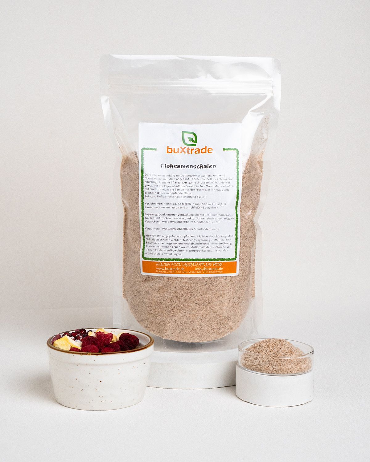 Verpackung mit Flohsamenschalen, daneben Schale mit Müsli und ein Glas mit Flohsamenschalen. Logo 'buXtrade'.