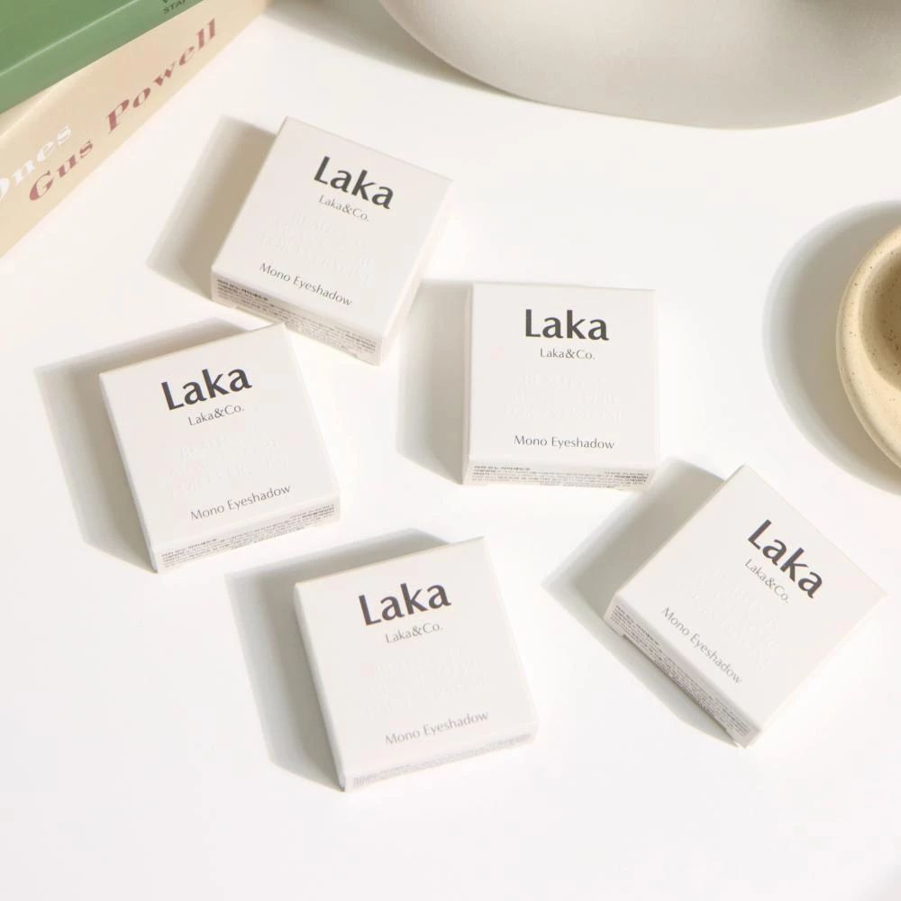Fünf kleine weiße Kartons mit der Aufschrift 'Laka Mono Eyeshadow' auf einer weißen Oberfläche.