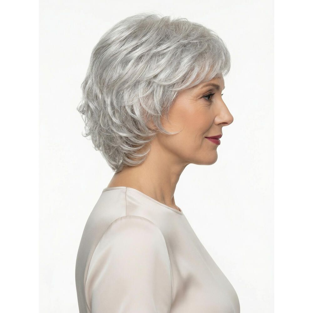 Frau mit grauer Perücke. Kurze, gewellte Frisur. Seitenansicht. Helles Oberteil. Weißer Hintergrund.