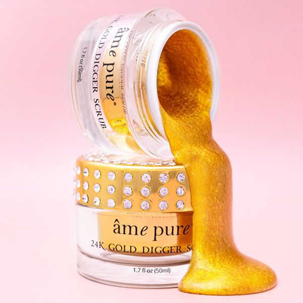 Twee potjes met goudkleurige scrub, waarvan één open. Goudkleurige scrub stroomt eruit. Opschrift: âme pure 24K GOLD DIGGER SCRUB.