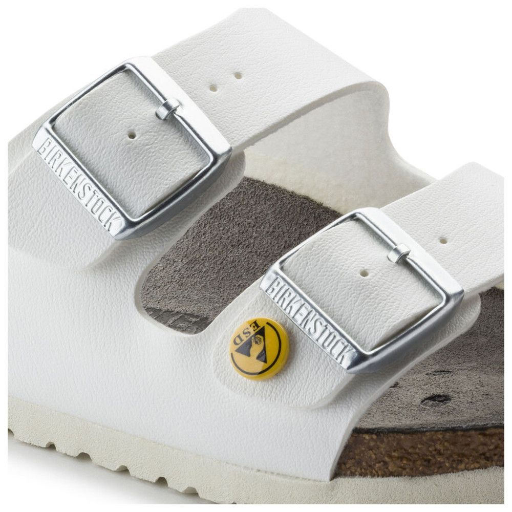 Nahaufnahme von weißen Sandalen mit zwei Schnallen. Birkenstock-Logo auf den Schnallen. ESD-Symbol.