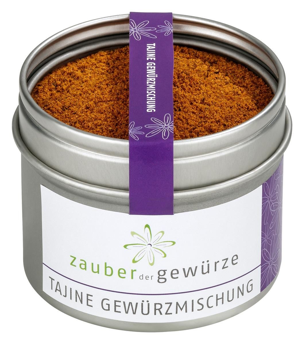 Runde Dose mit Tajine Gewürzmischung. Silberne Dose mit weißem Etikett und lila Band. Aufschrift: Zauber der Gewürze, Tajine Gewürzmischung.