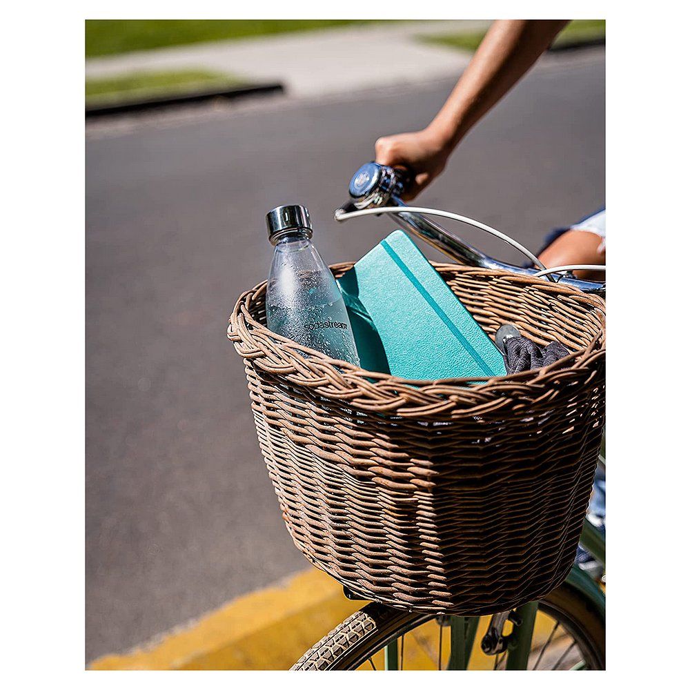 Wiederverwendbare Wasserflasche aus Glas mit silbernem Verschluss, in einem Fahrradkorb.