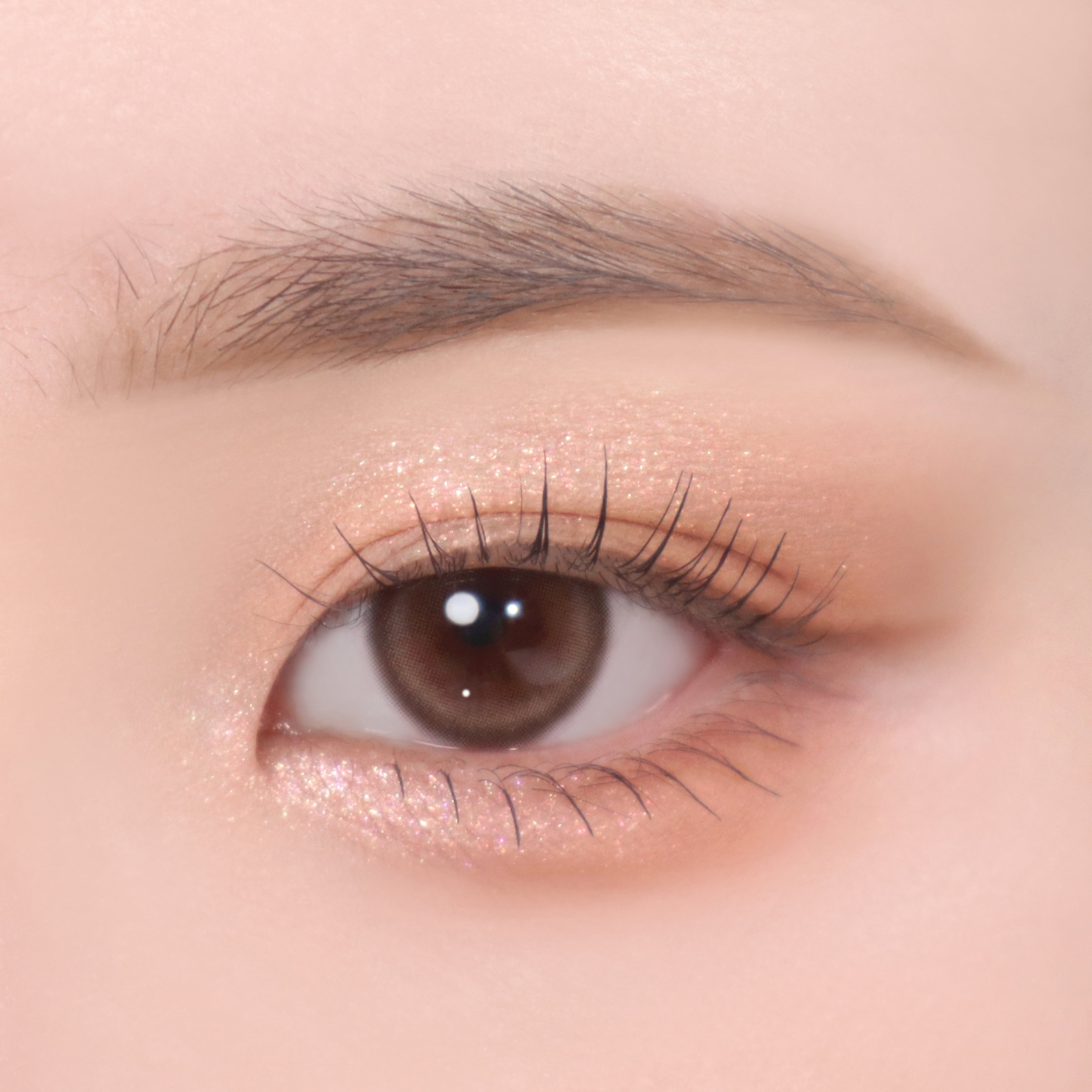 Auge mit Lidschatten in Nude-Tönen. Glitzer-Effekt auf dem Augenlid.