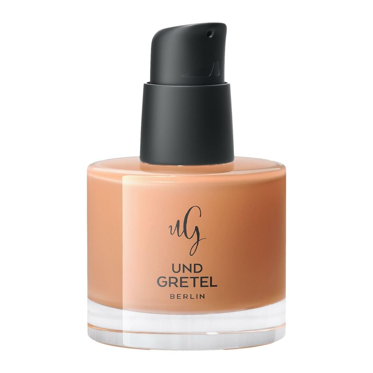 Beige Creme-Flüssigkeit in Glasflasche mit schwarzem Pumpverschluss. Schriftzug: UND GRETEL BERLIN.