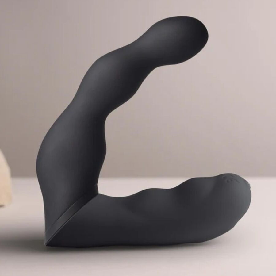 Schwarzer Vibrator mit gebogener Form. Zwei Enden, ein längeres und ein kürzeres, verbunden durch einen gebogenen Mittelteil.