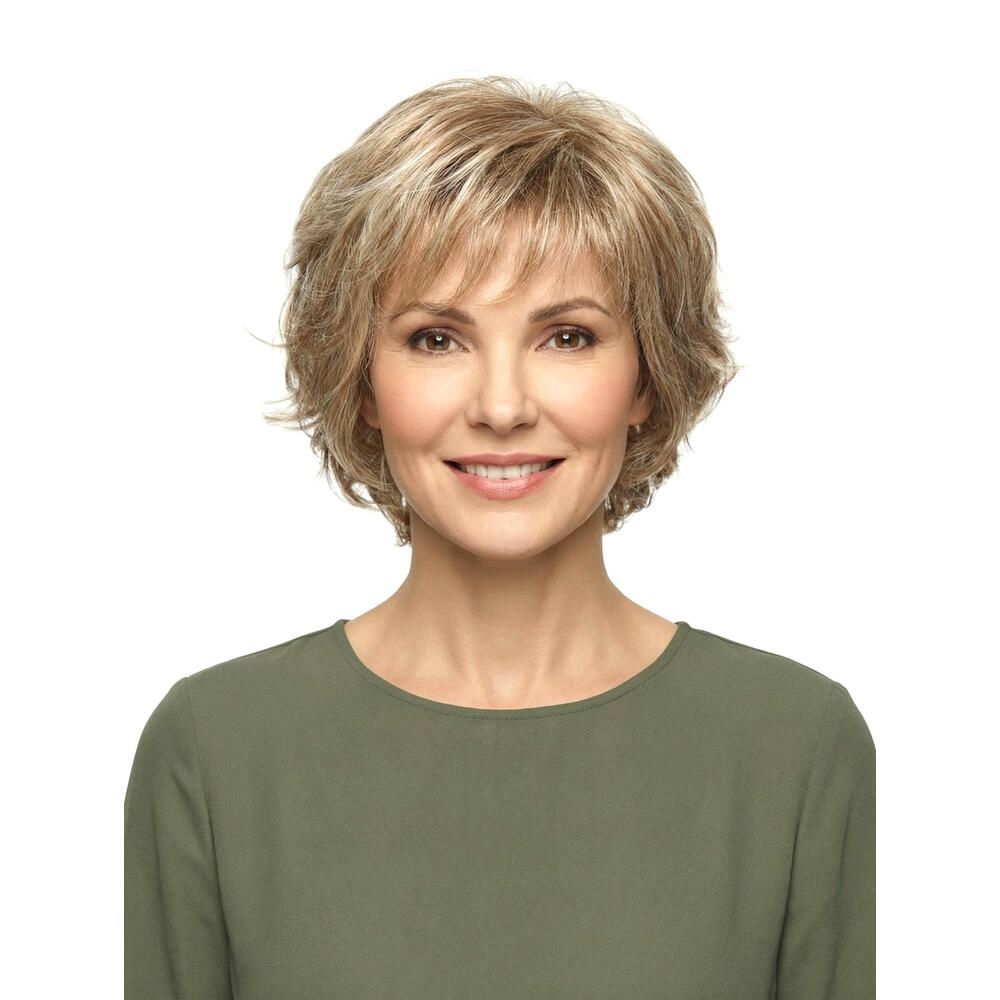 Kurzhaarperücke mit blonden Strähnen. Frontale Ansicht einer Frau mit Perücke und grünem Oberteil. Blick in die Kamera.