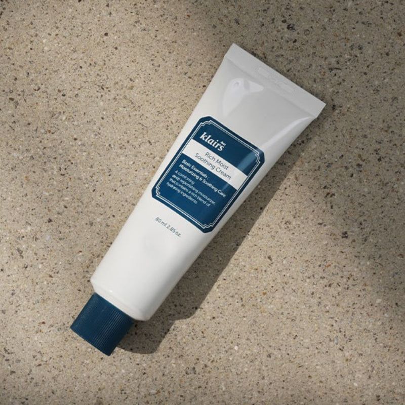 Weiße Tube mit blauem Verschluss auf Stein. Aufschrift: Klairs Rich Moist Soothing Cream.