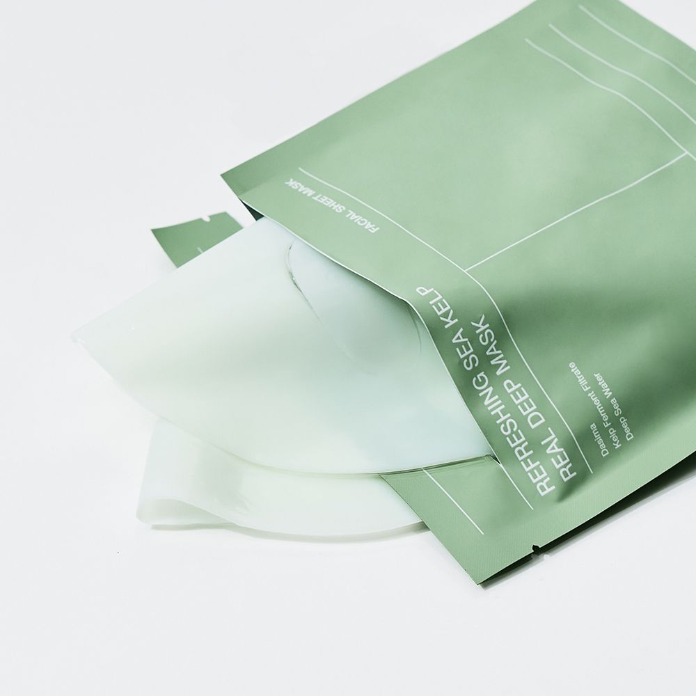 Grüne Verpackung mit zwei Gesichtsmasken. Aufschrift: Refreshing Sea Kelp Real Deep Mask. Produktname und Details.