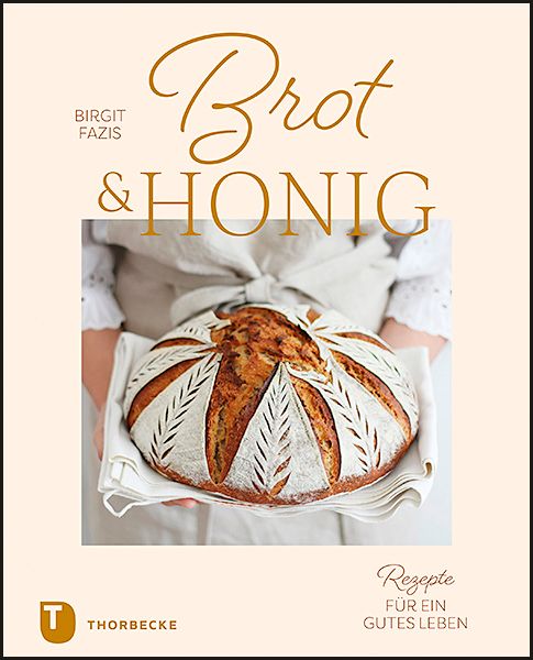 Buchcover mit Brot & Honig. Titel in goldener Schrift. Darunter ein Brot auf einem weißen Tuch, gehalten von einer Person.