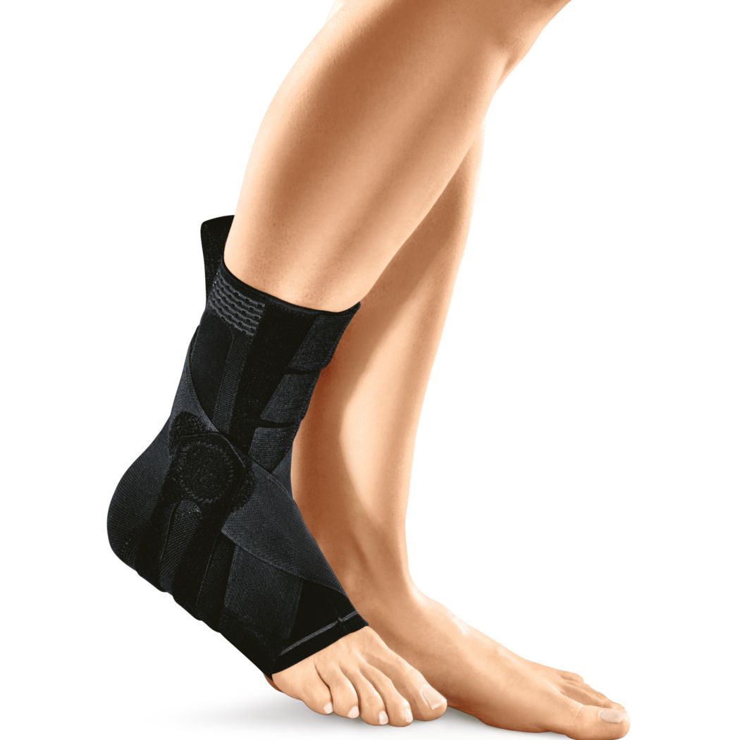 Schwarze Fußheberorthese am Bein. Knöchelbandage mit Klettverschlüssen und Riemen. Am Fuß getragen.