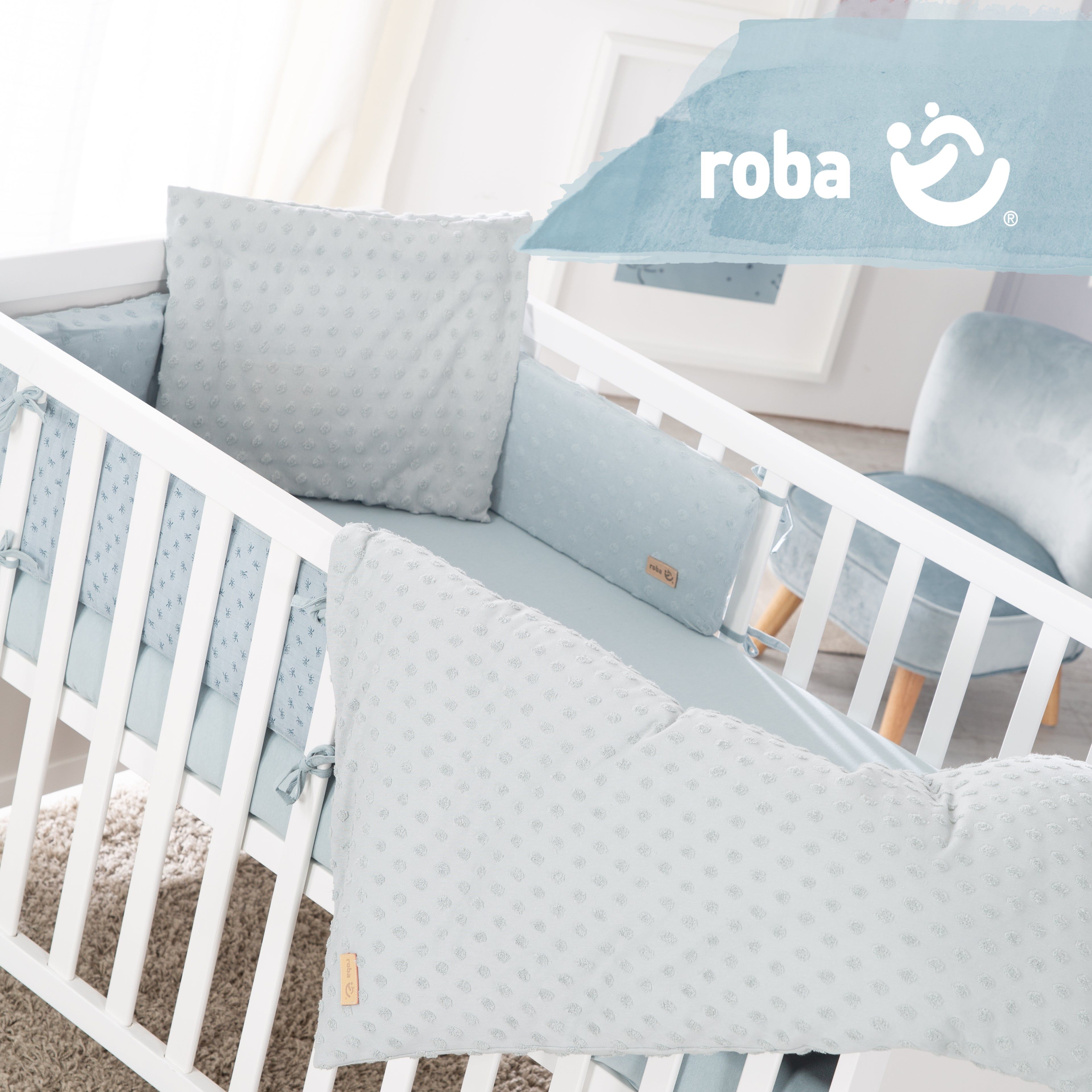 Babybett-Set mit Kissen, Nestchen und Bettwäsche. Hellblaues Design mit kleinen Punkten. Logo: roba.